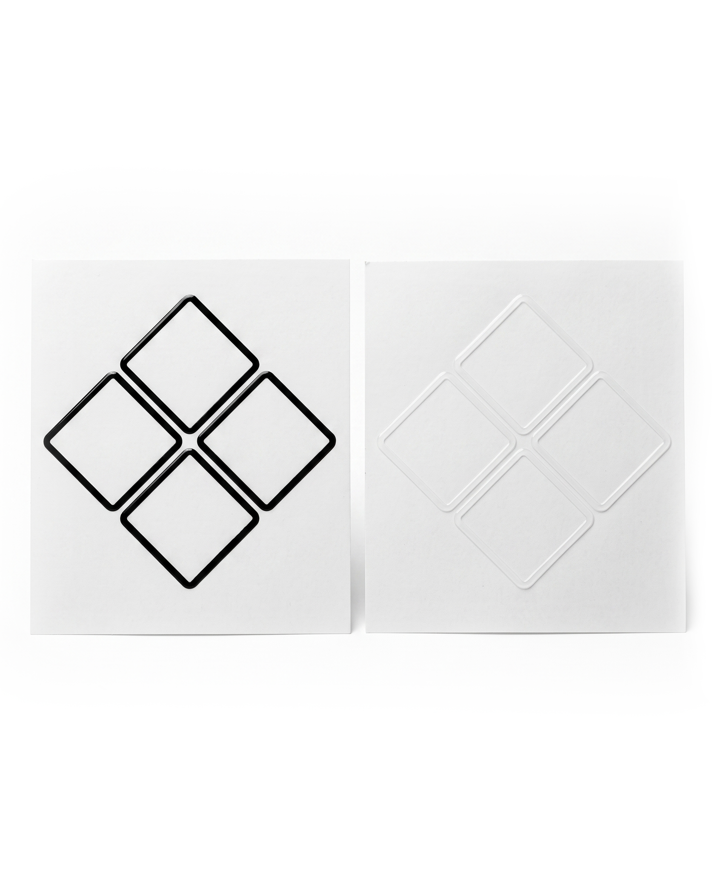 A pair of square white decals or stickers shown side by side on a white background. The left sticker features a black outline of four connected diamond shapes, while the right sticker shows the corresponding white recessed or embossed diamond pattern.